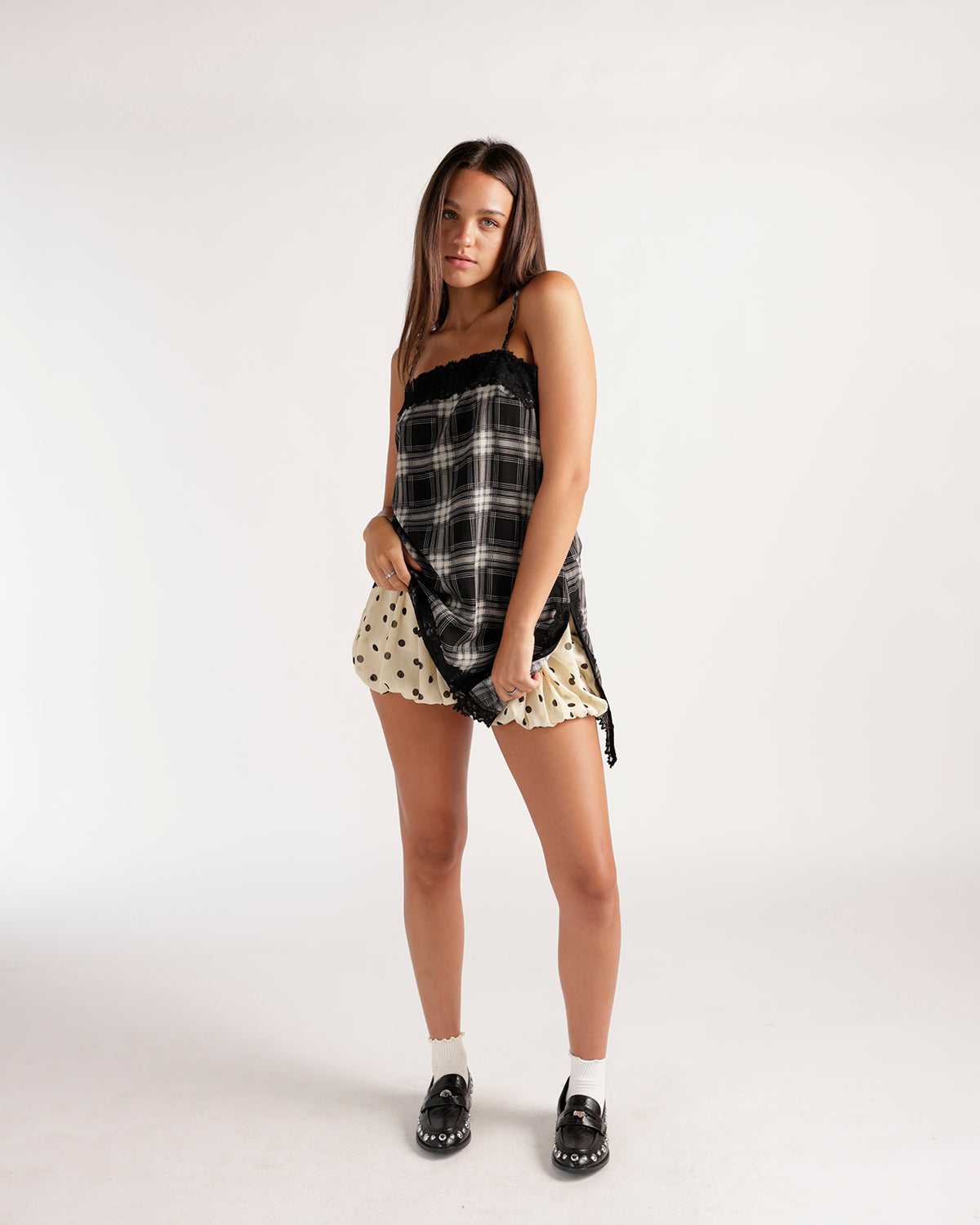 Cream polka dot bubble skort with ruffled hem, worn with plaid top and loafers