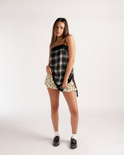 Cream polka dot bubble skort with ruffled hem, worn with plaid top and loafers