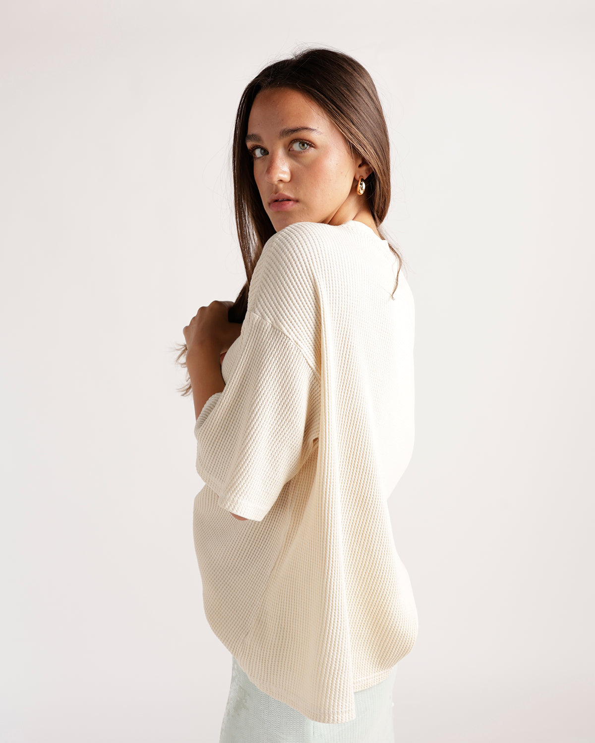 Cream ribbed short-sleeve oversized tee shown from the back on a model.
