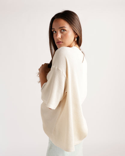 Cream ribbed short-sleeve oversized tee shown from the back on a model.