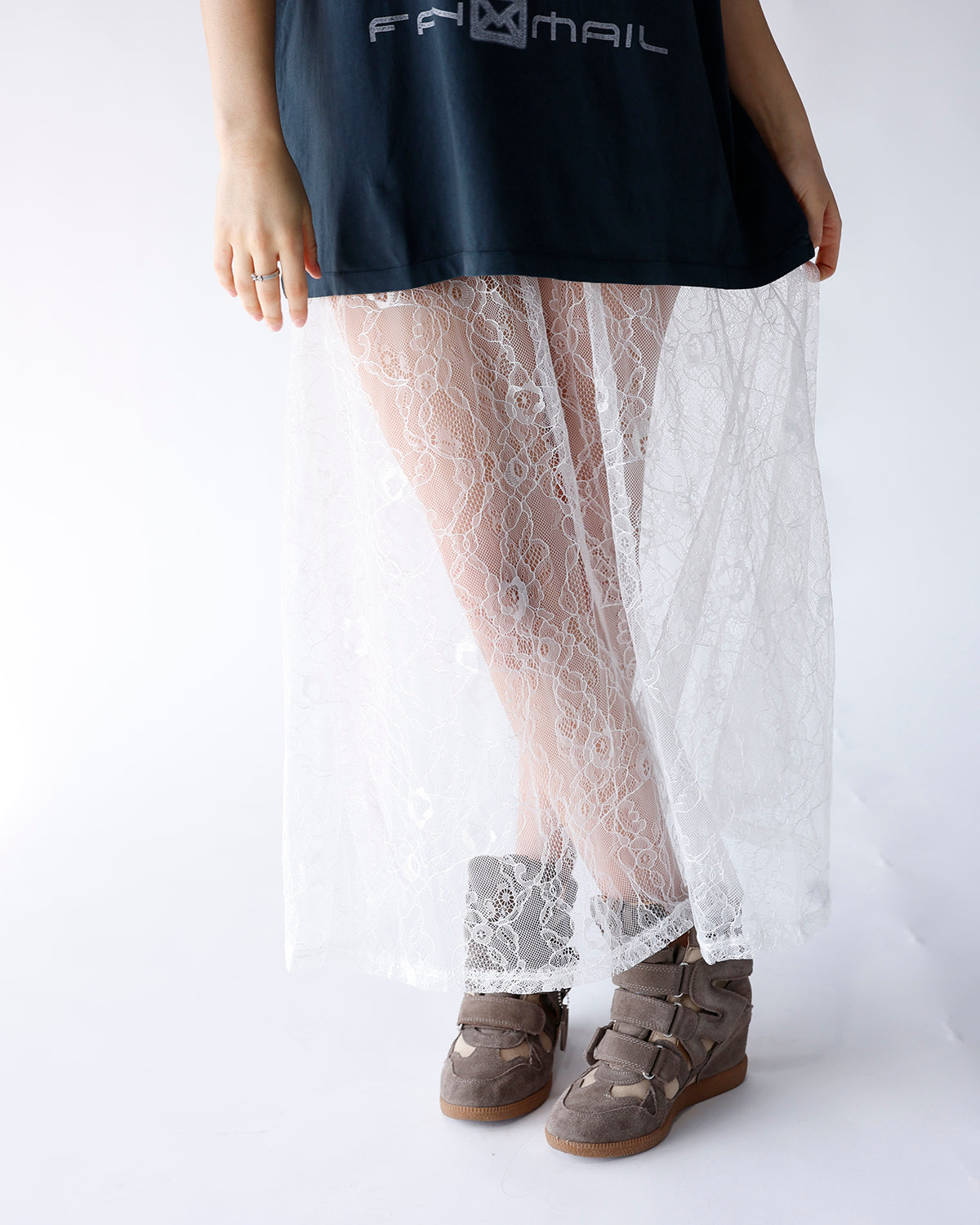 White floral lace maxi skirt styled with dark graphic tee and gray sneakers