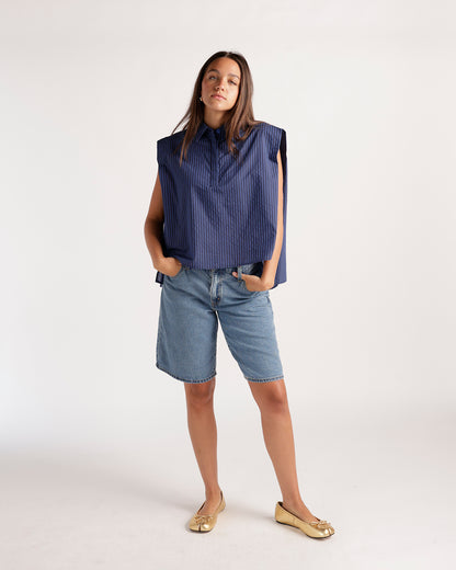 Navy blue pinstripe sleeveless cropped shirt with structured shoulders and collar