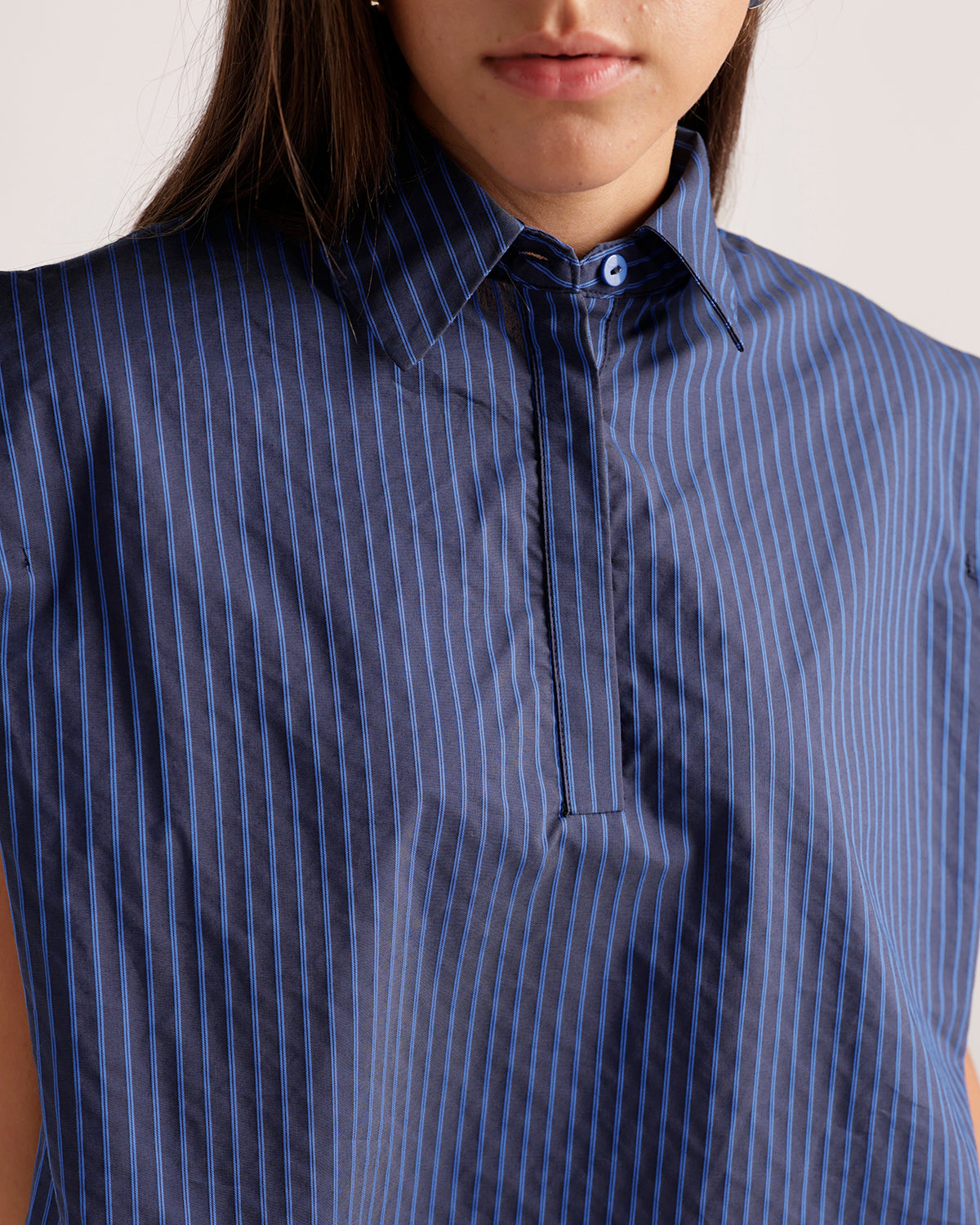 Navy blue pinstripe sleeveless collared top with hidden button placket