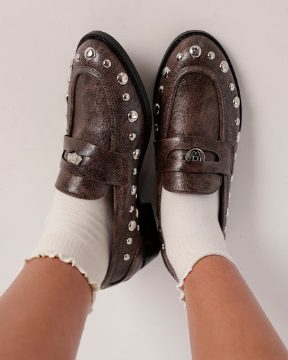 Dark taupe studded leather loafers with silver dome studs, worn with white frilly socks