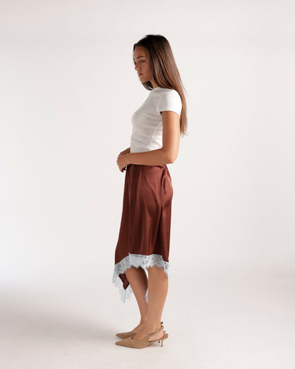 Brown satin asymmetric midi skirt with white lace hem, styled with white tee