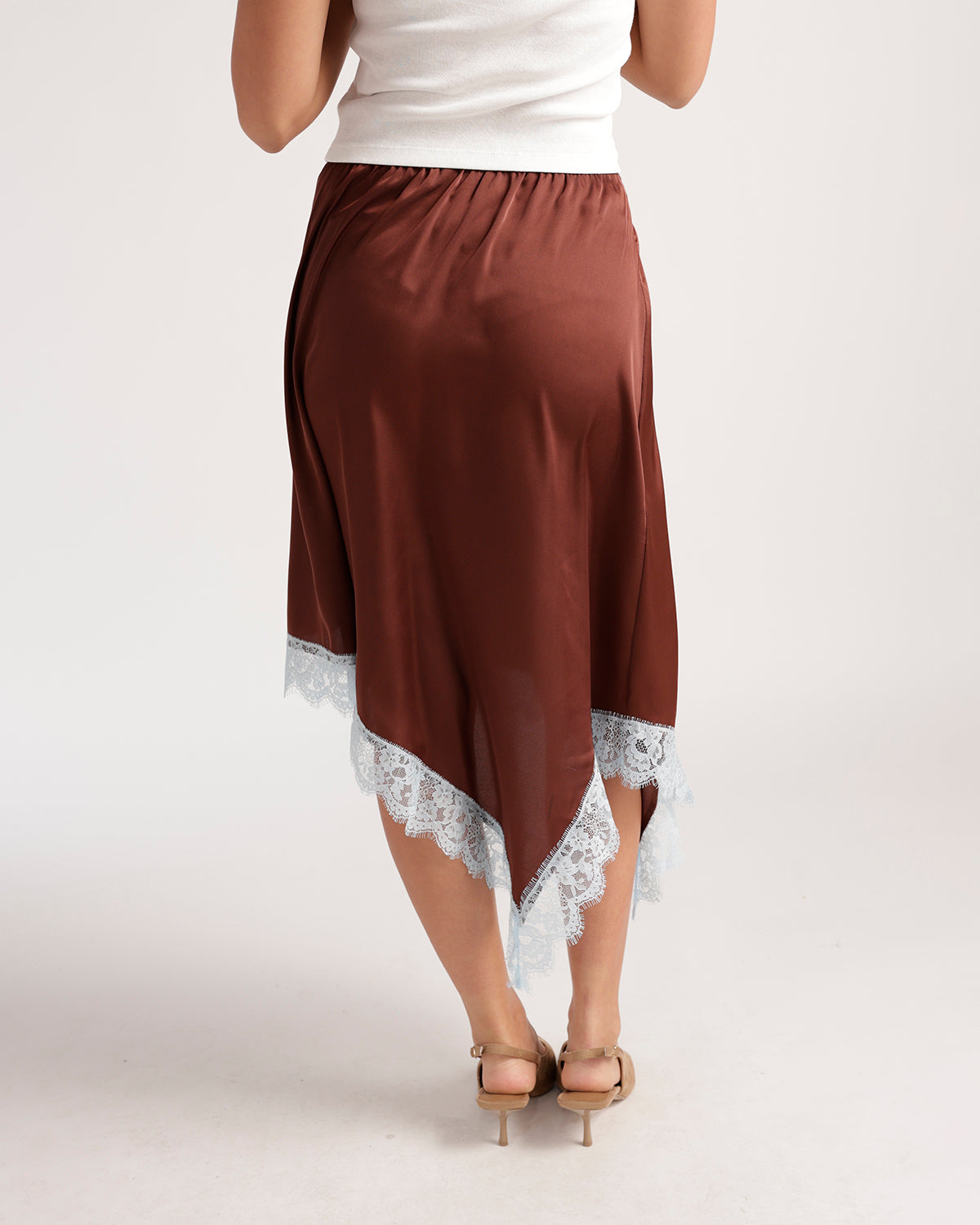 Brown satin asymmetric midi skirt with white lace trim hem, back view