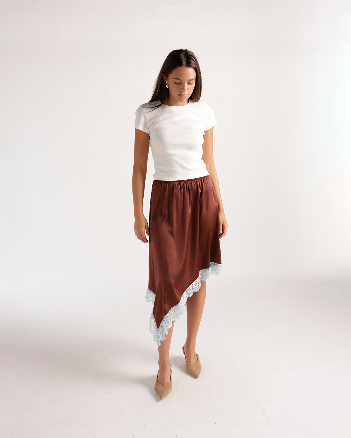 Brown satin asymmetric midi skirt with white lace trim, styled with white tee
