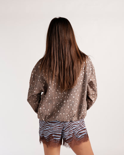 Brown spotted fawn print jacket with drop shoulders, worn over zebra print shorts