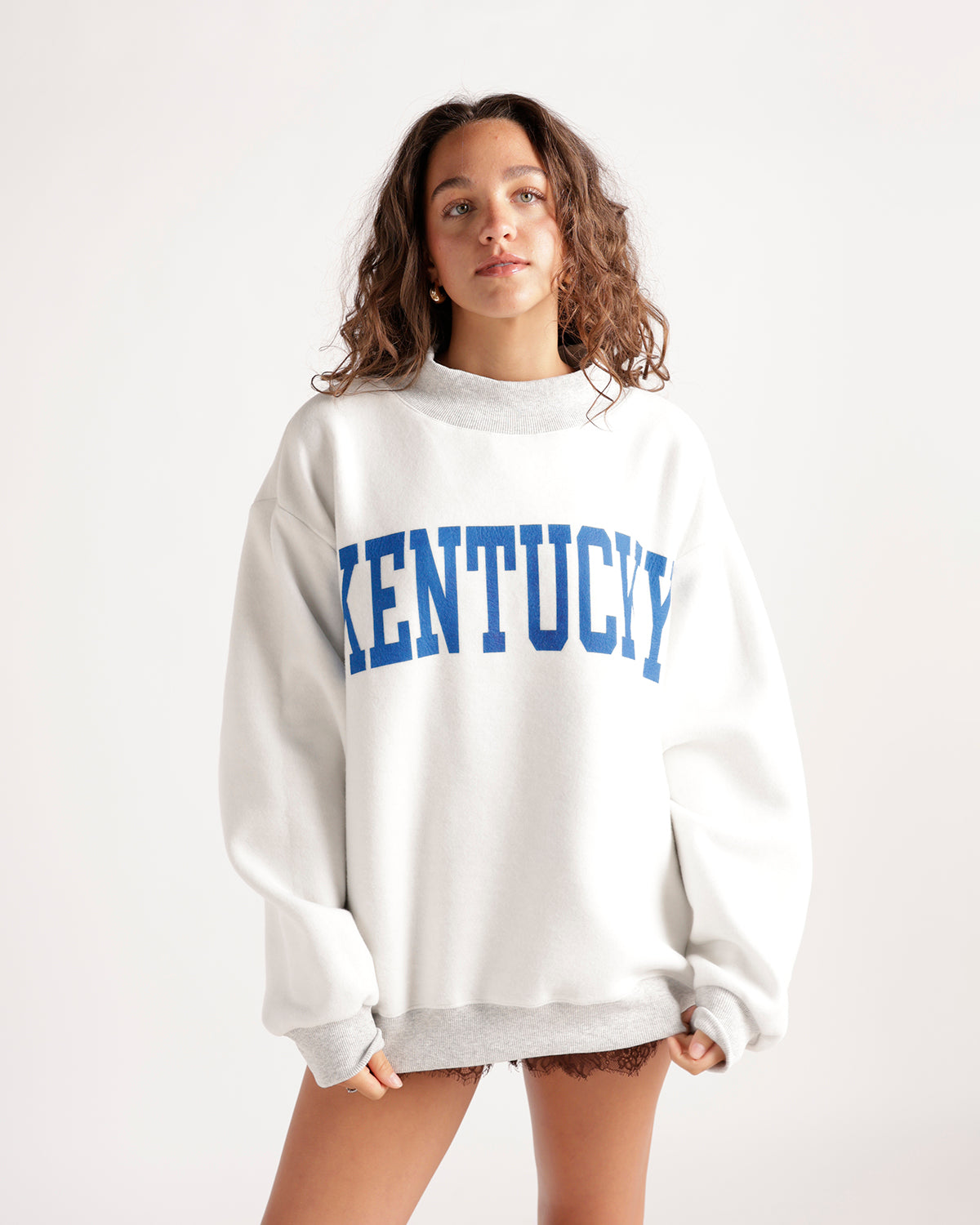 Oversized white crewneck sweatshirt with bold blue Kentucky collegiate graphic lettering