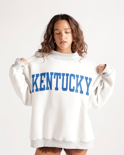 Oversized white crewneck sweatshirt with bold blue Kentucky collegiate lettering
