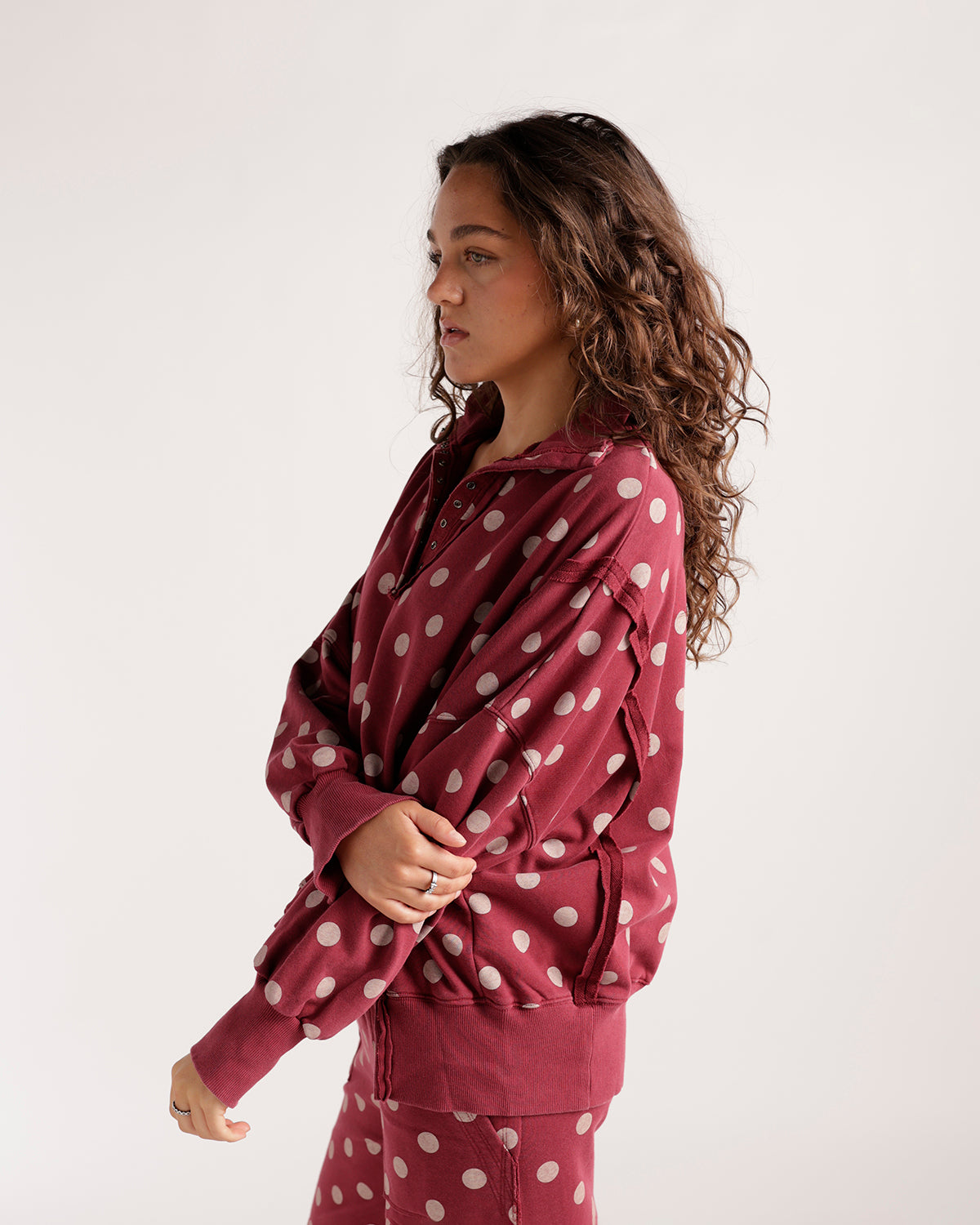 Berry red polka dot pullover sweatshirt with henley neckline and ribbed cuffs