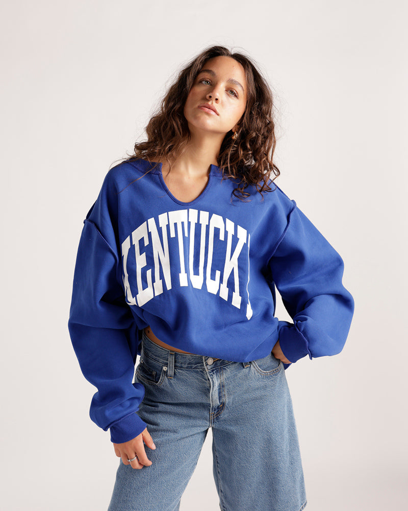 Cropped royal blue Kentucky sweatshirt with split neck and white varsity lettering