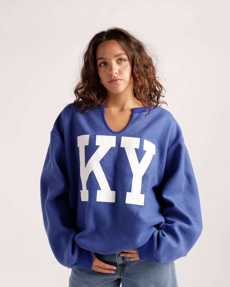Oversized blue split-neck sweatshirt with large white KY letters on front