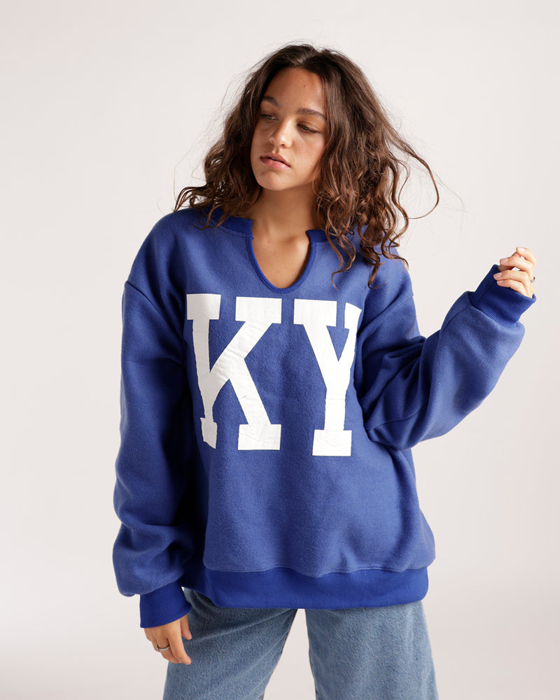 Oversized blue split-neck sweatshirt with large white KY letters on front