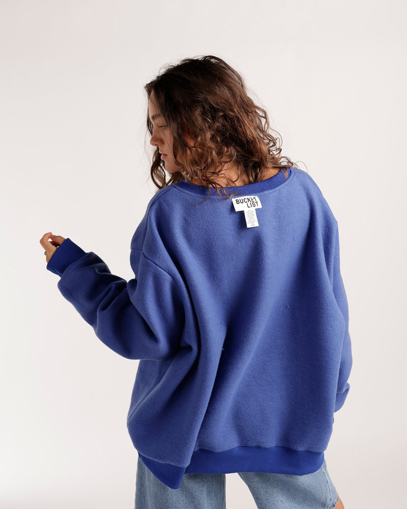 Oversized blue reversible crewneck sweatshirt shown from the back on a model