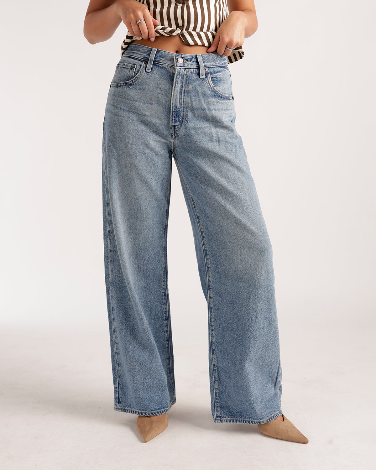 Wide leg light wash blue denim jeans with relaxed fit and vintage fading