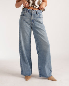 Wide leg light wash blue denim jeans with relaxed fit and vintage fading