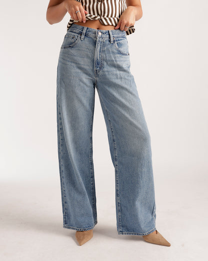 Wide leg light wash blue denim jeans with relaxed fit and vintage fading