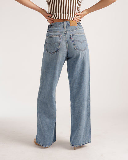Light wash wide leg jeans with back pockets, worn with a striped crop top