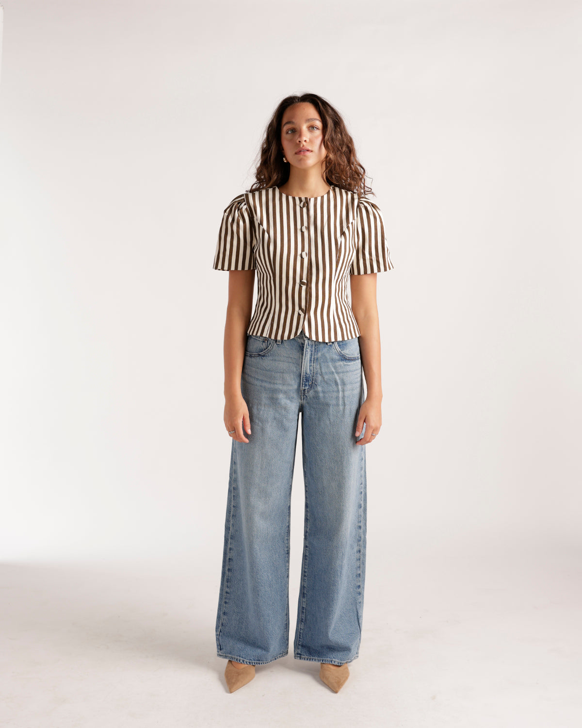 Light wash wide leg jeans styled with a brown striped button-up top