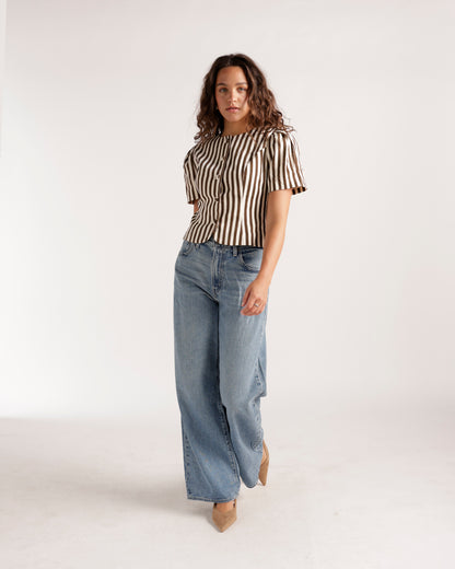 Wide leg light wash blue denim jeans with relaxed fit and raw hem