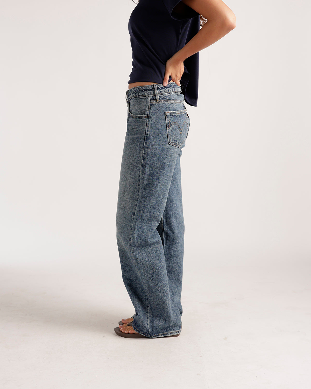 Women's wide-leg low-rise medium wash blue denim jeans, side view