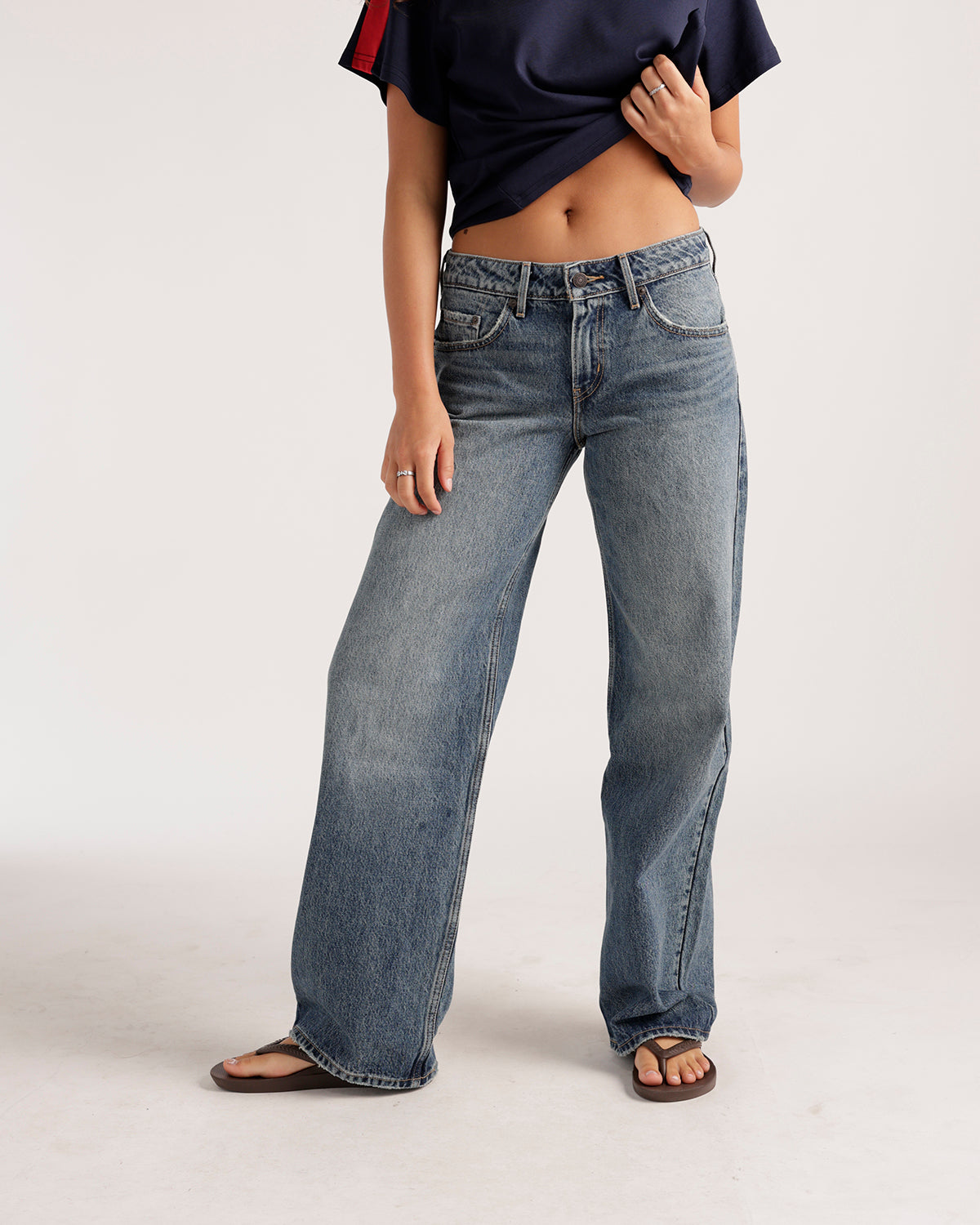 Low-rise wide-leg medium wash blue denim jeans with faded distressing