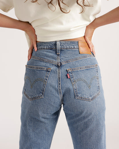 Back view of light blue wash straight-leg jeans with arc pocket stitching