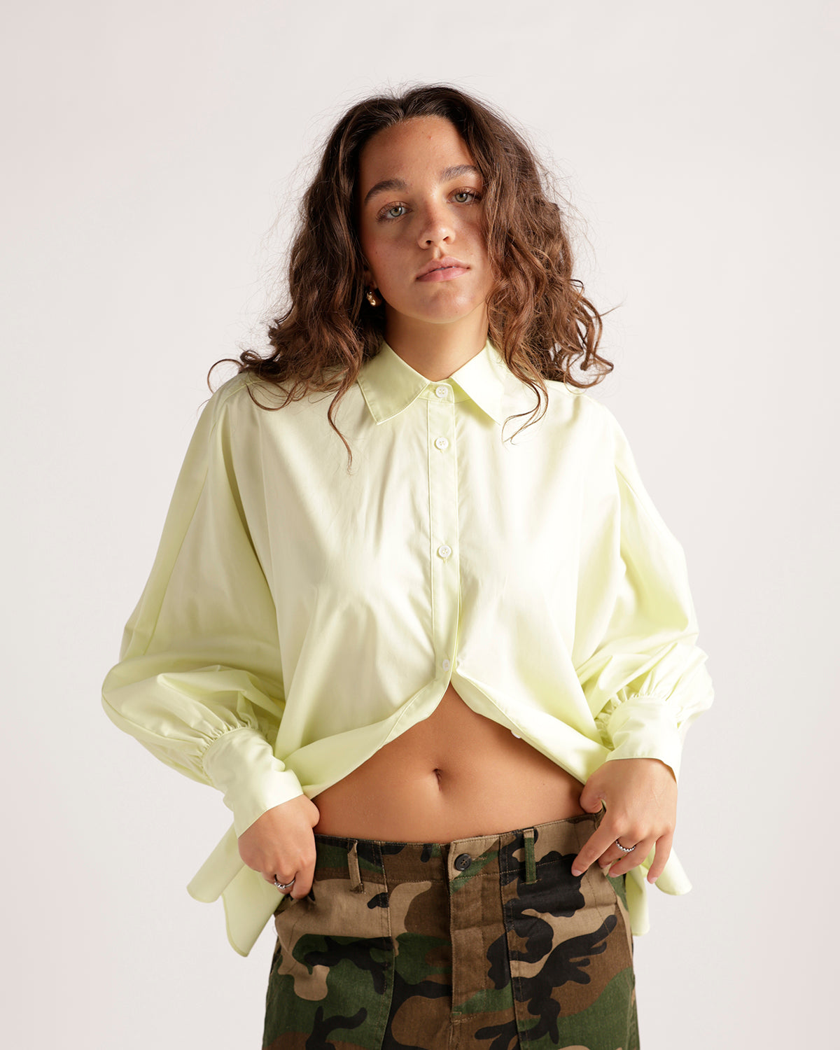 Cropped pale yellow button-up shirt with long sleeves and elastic cuffs