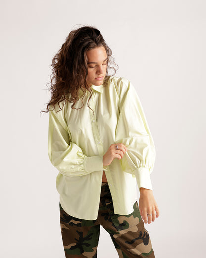 Pale yellow long sleeve button-up shirt with billowy sleeves and ruffled cuffs