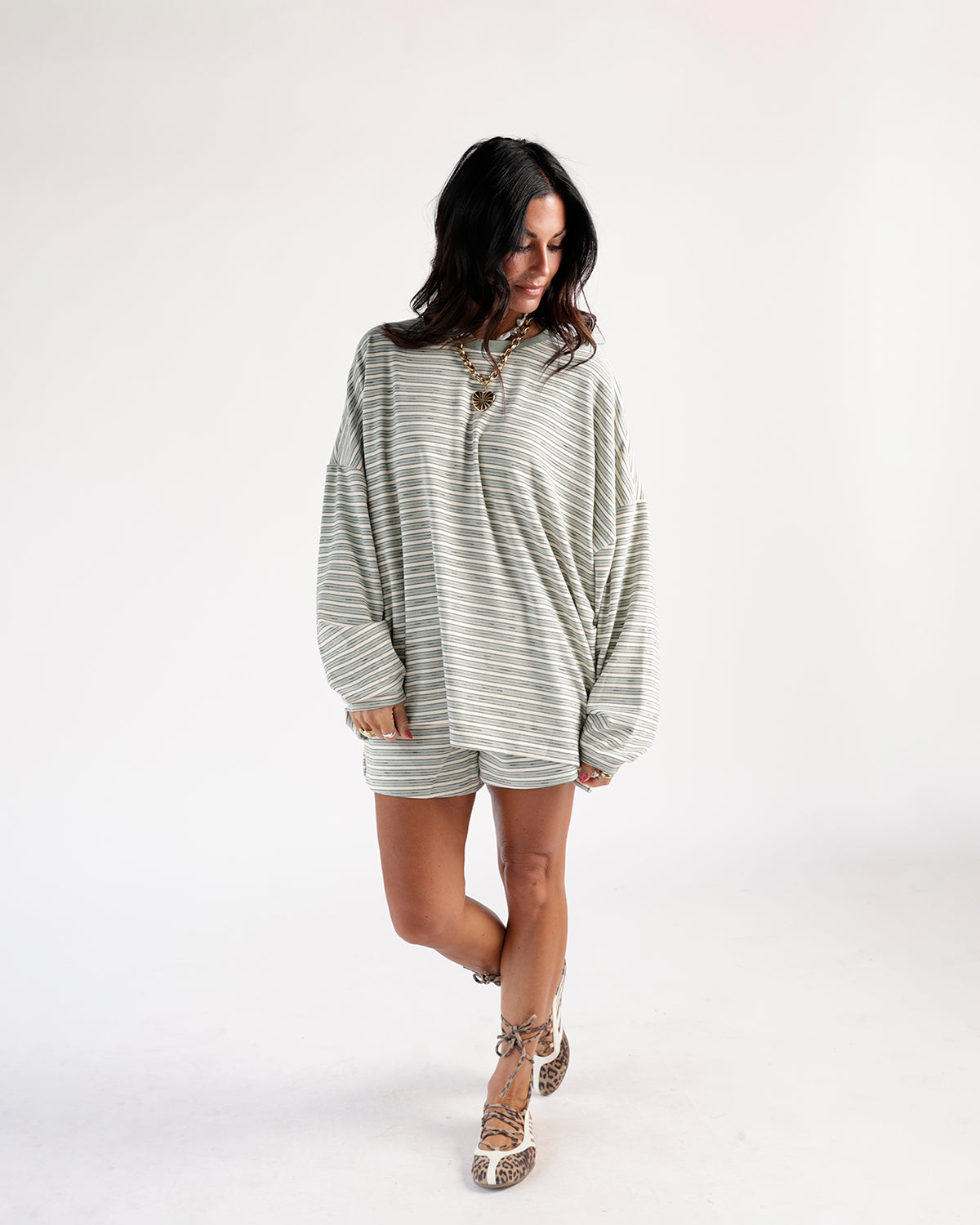 Sage green and white striped casual shorts with relaxed fit, worn with matching top