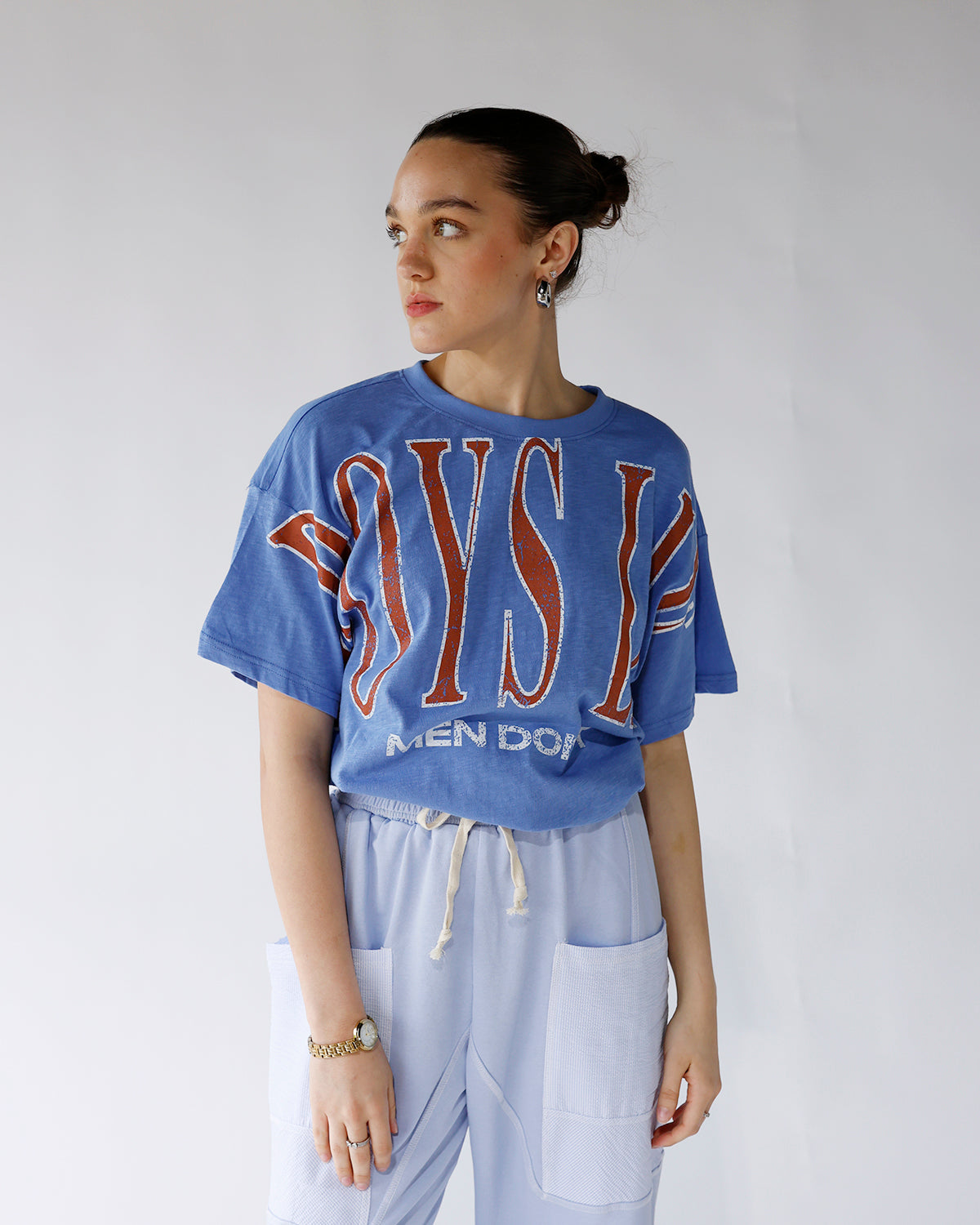 Oversized blue graphic tee with red lettering, worn with light blue drawstring pants