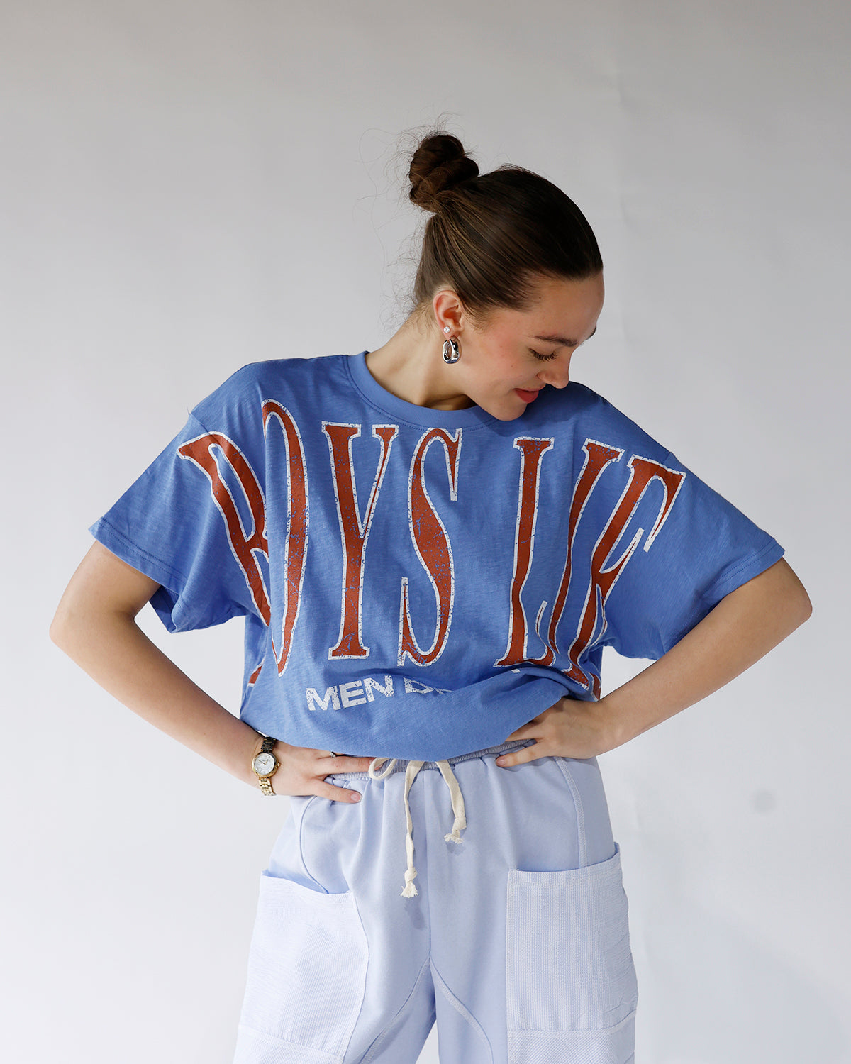 Oversized blue graphic tee with bold red varsity text, cropped fit, short sleeves