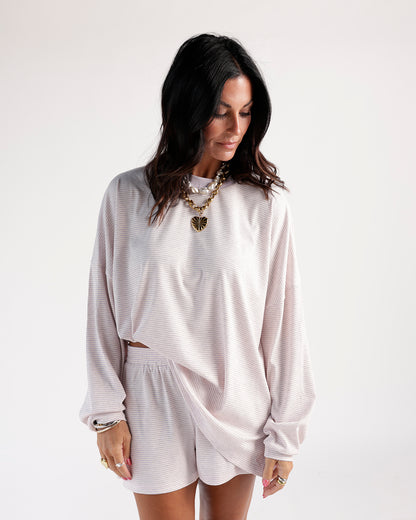 Lilac striped shorts with wrap-style hem, worn with matching long-sleeve top
