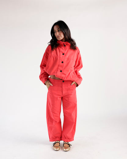 Cropped red funnel neck jacket with black buttons, worn as a matching set