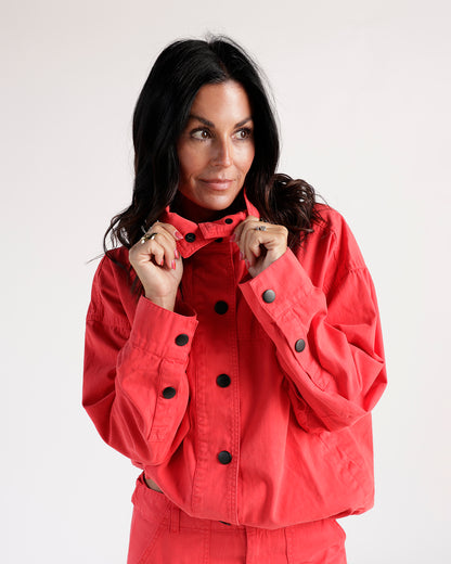 Cropped red jacket with black snap buttons and funnel neck collar