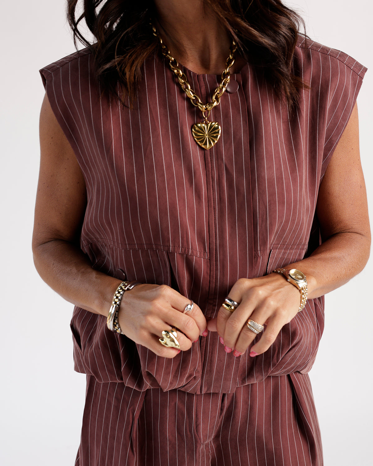 Mulberry striped sleeveless cargo zip vest worn with gold chain heart necklace and rings