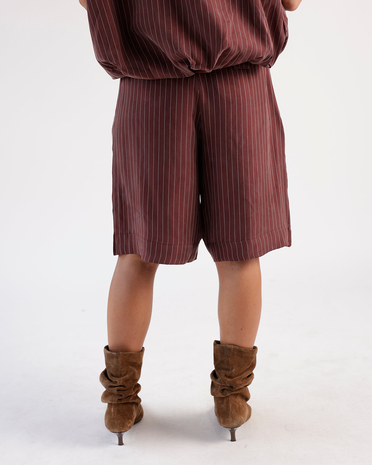 Mulberry pinstripe long shorts paired with matching top and brown suede boots