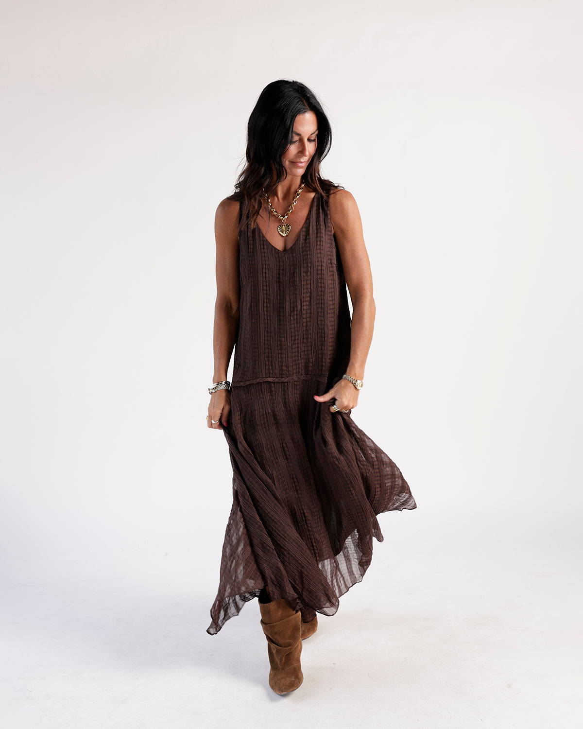 Brown plaid crinkle maxi dress with V-neck, sleeveless silhouette, and tiered skirt