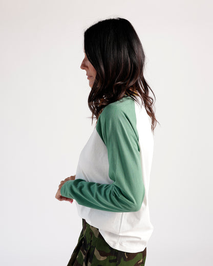 White and sage green raglan long sleeve tee, side view, paired with camo pants.