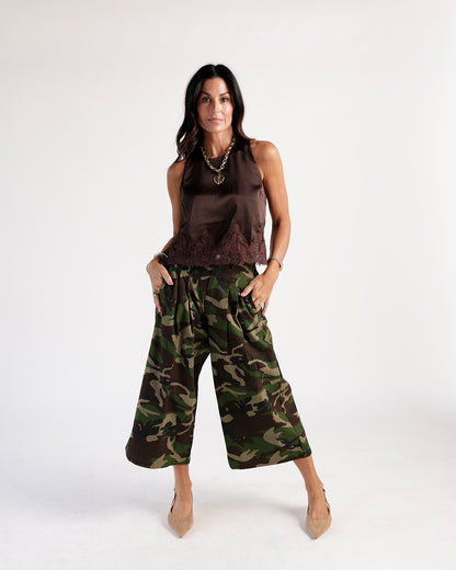 Wide-leg cropped camo pants in green and brown, styled with brown satin top