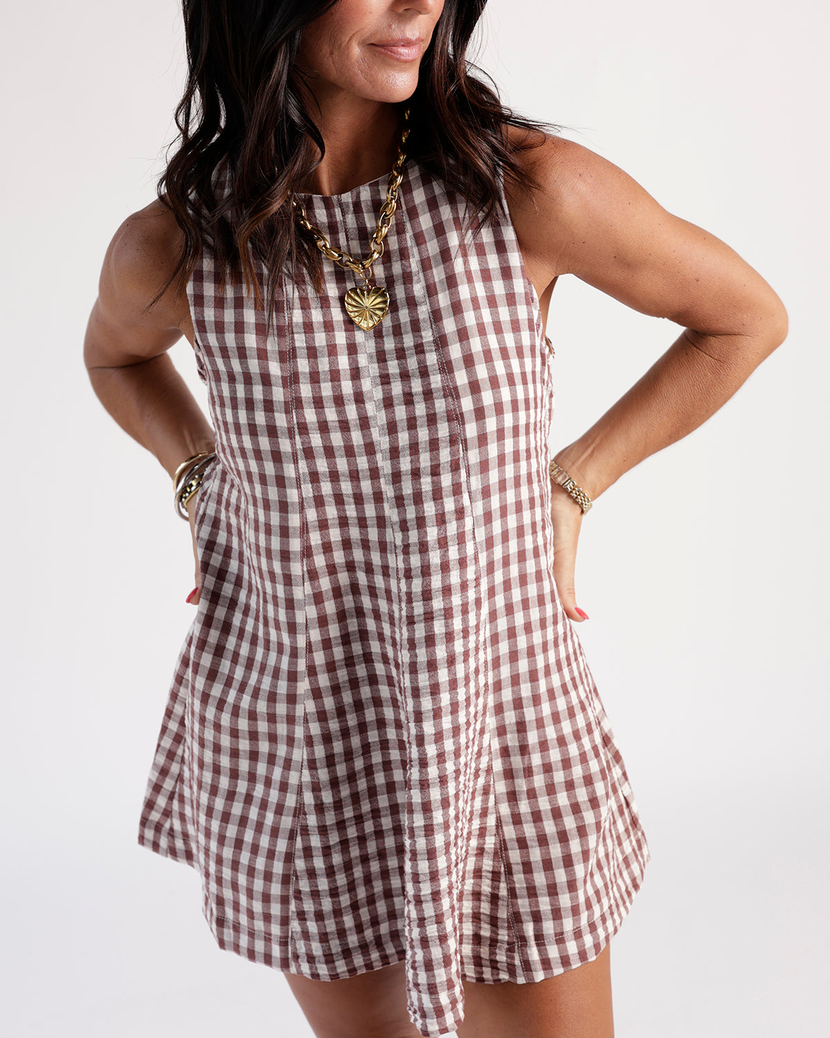 Sleeveless brown and white gingham mini dress with seam detailing and high neck