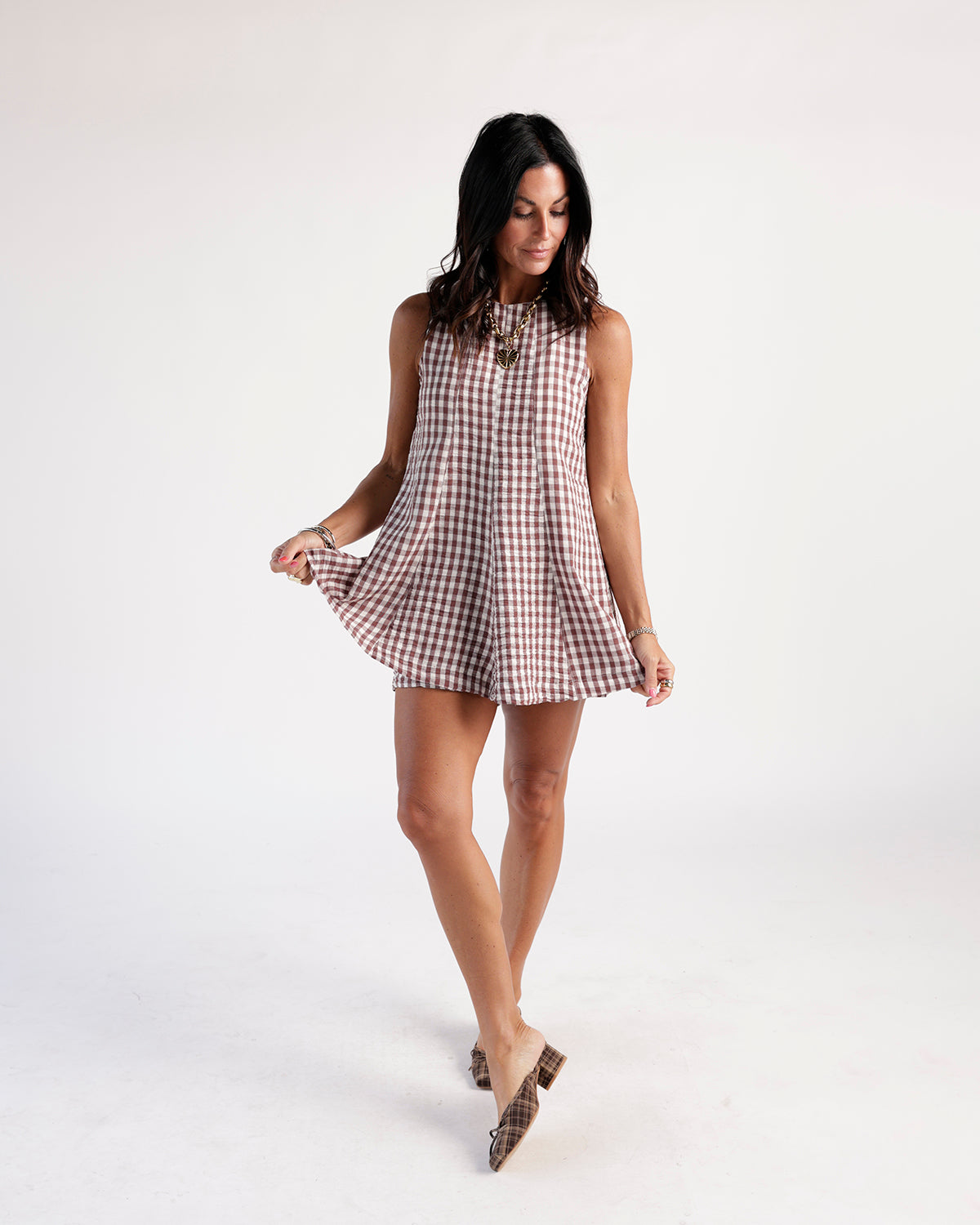 Sleeveless brown gingham mini romper dress with mock neck and flared skirt