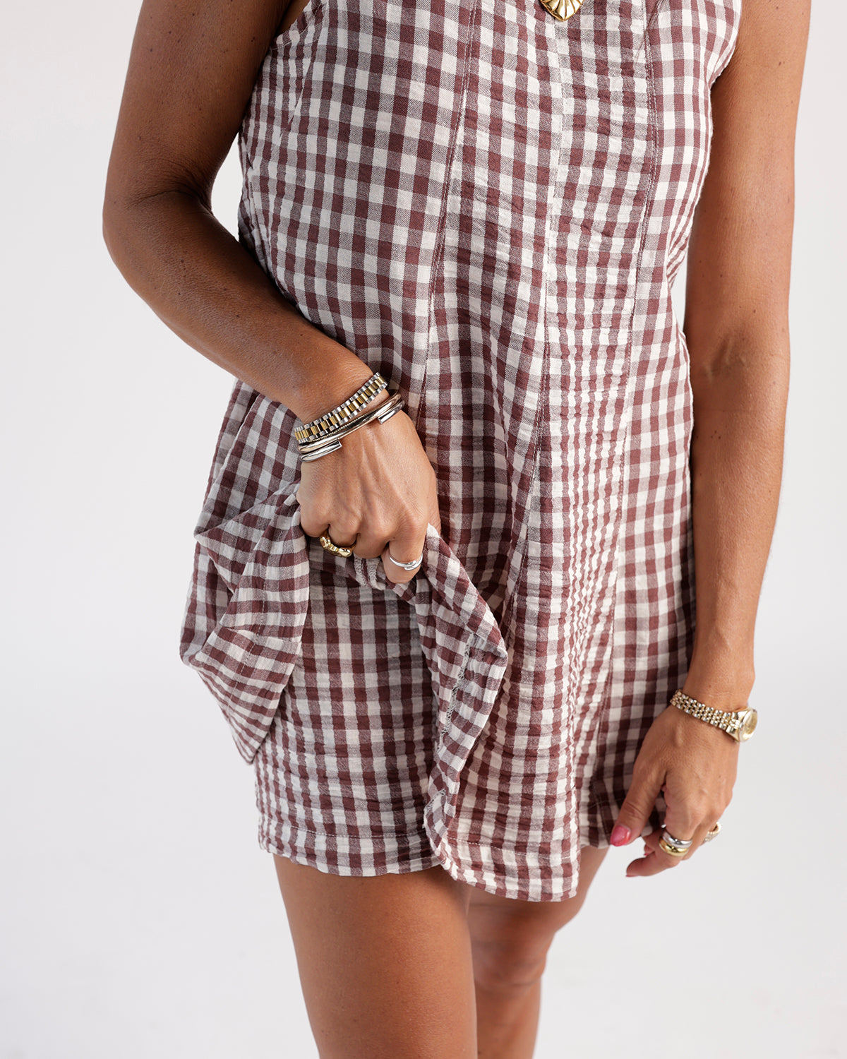 Burgundy and white gingham mini dress with ruched pocket detail and bracelet stack