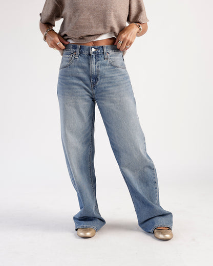 Relaxed wide-leg medium wash blue jeans with faded detailing and five pockets