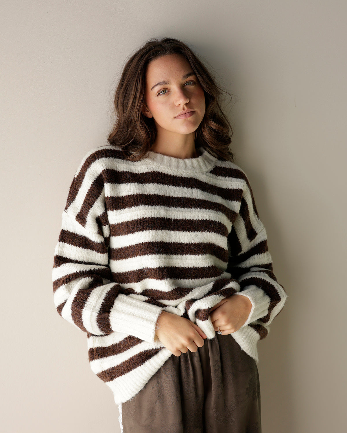 brown and white cream striped sweater on a women 