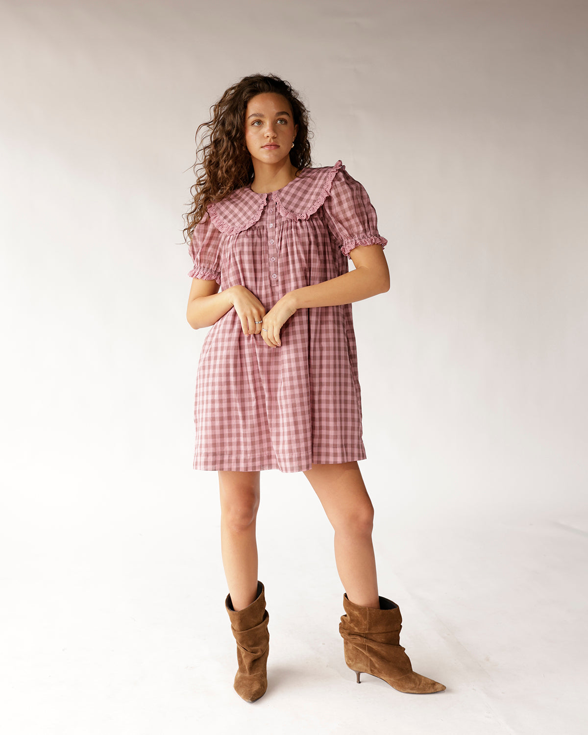 Pink gingham mini dress with peter pan collar, puff sleeves, and button front