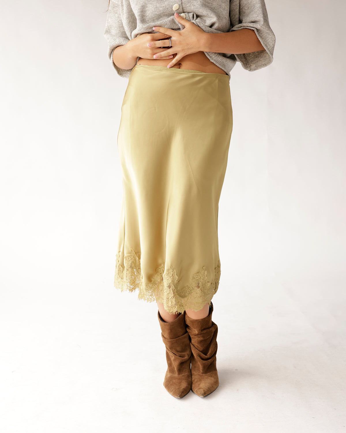 Olive green satin midi skirt with lace trim hem, styled with brown suede boots