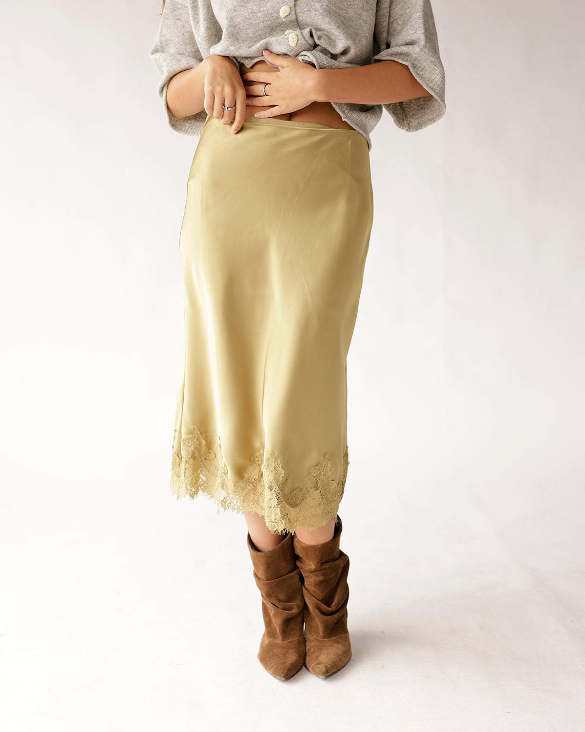Olive satin midi skirt with lace hem trim, styled with brown suede boots