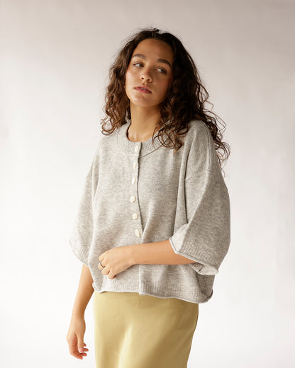 Our comfortable gray knit sweater is perfect for layering. Features a relaxed fit, button-front closure, and raw edge finish for a casual look.
